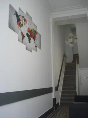 a hallway with stairs and paintings on the wall at Modern Apartment First Floor in Brussels