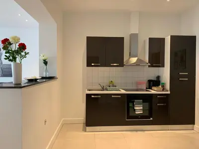 a kitchen with black cabinets and a vase of flowers at Modern Apartment First Floor in Brussels