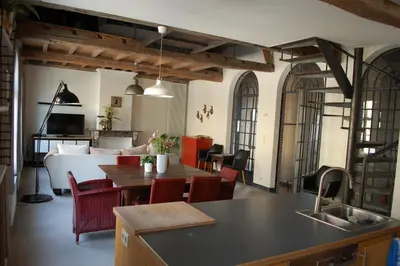 a kitchen and living room with a table and chairs at Rubbensloft in Zele