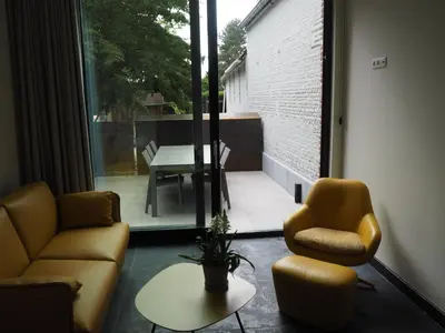 a living room with two chairs and a table at Rubbensloft in Zele