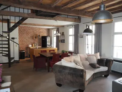 a living room with a couch and a table at Rubbensloft in Zele