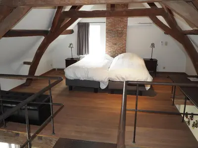 two beds in a room with a loft at Rubbensloft in Zele