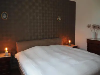 a bedroom with a white bed and two night stands with candles at Gadering in Zele