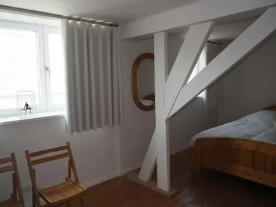 a bedroom with a staircase and a bed and a chair at Gadering in Zele