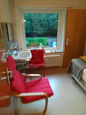 a room with a chair and a sink and a window at B+B GOLF SCHILDE in Schilde