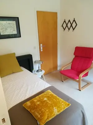 a bedroom with a bed and a red chair at B+B GOLF SCHILDE in Schilde