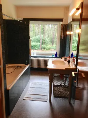 a bathroom with a sink and a tub and a window at B+B GOLF SCHILDE in Schilde