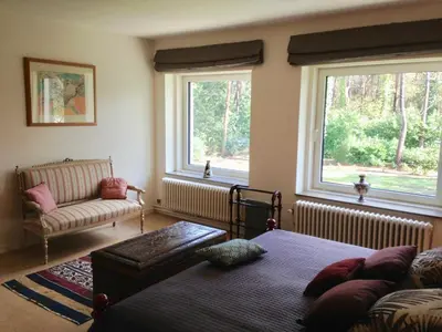 a living room with a couch and two windows at B+B GOLF SCHILDE in Schilde