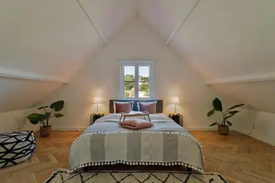 a bedroom with a large bed in a attic at Scheldewegel Vakantiehuis in Schelderode