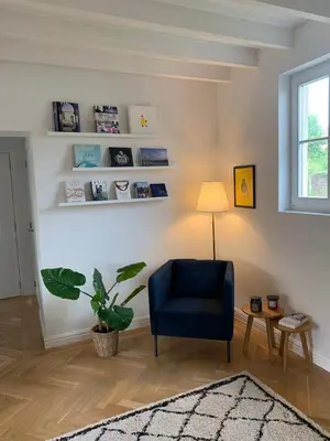 a living room with a blue chair and a plant at Scheldewegel Vakantiehuis in Schelderode