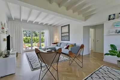 a living room with a couch and a table and chairs at Scheldewegel Vakantiehuis in Schelderode