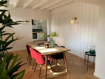 a dining room with a table and pink chairs at Scheldewegel Vakantiehuis in Schelderode
