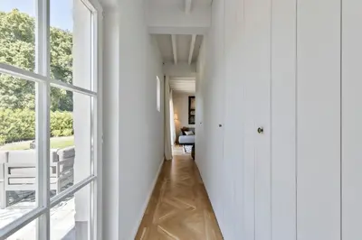 a hallway of a house with white walls and windows at Scheldewegel Vakantiehuis in Schelderode