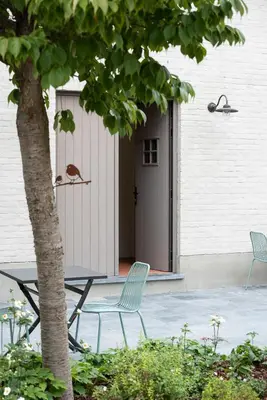 two chairs and a table in front of a door at B&B Hof Beygaert in Aalst