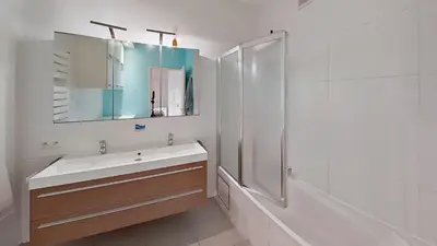 a bathroom with a sink and a shower and a mirror at nice and cosy apartment in Edegem