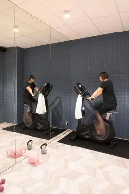 a man riding on an exercise bike in a bathroom at ROXI The Urban Residence Brussels in Brussels