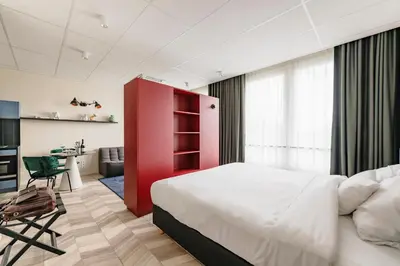 a bedroom with a large bed and a red cabinet at ROXI The Urban Residence Brussels in Brussels