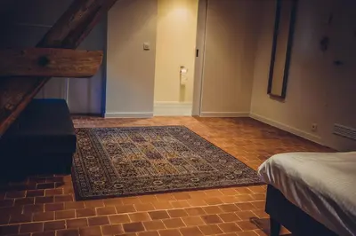 a hallway with a rug on the floor and a staircase at Hotel Colonie 7 in Merksplas