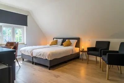 a bedroom with a large bed and two chairs at Hotel Huron in Mol