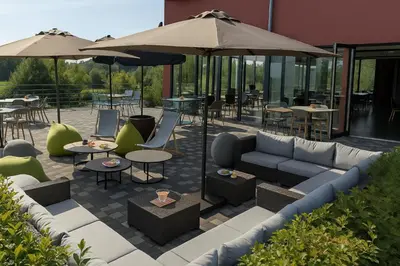 a patio with a couch and tables and umbrellas at OFF in Wavre