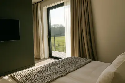 a bedroom with a bed and a large window at OFF in Wavre