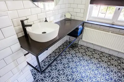 a bathroom with a white sink on a black counter at OsTi in Ghent