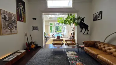 a living room with a couch and a cat on the wall at OsTi in Ghent