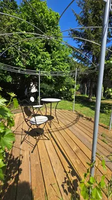 a table and a chair on a wooden deck at OsTi in Ghent