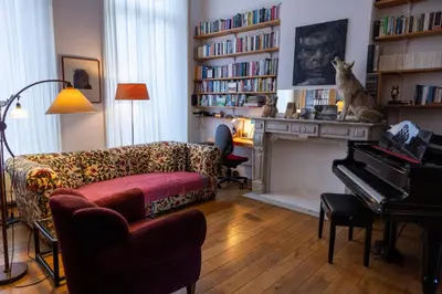 a living room with a couch and a cat sitting on a piano at Heaven in Antwerp in Antwerp