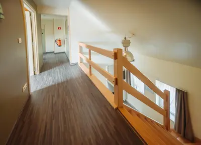 a staircase in a house with a wooden railing at De Holsterhoeve in Beringen