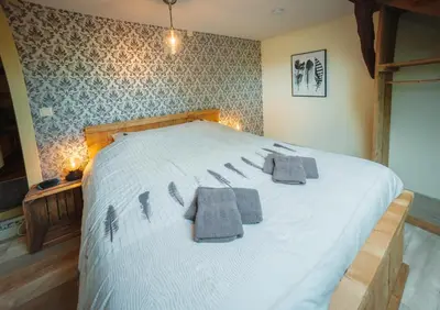 a bedroom with a large white bed with towels on it at De Holsterhoeve in Beringen