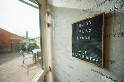 a sign on the side of a building with a window at De Holsterhoeve in Beringen