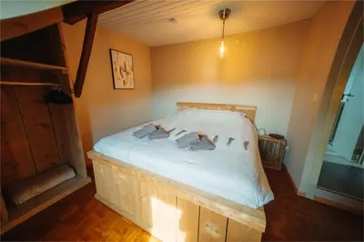 a bedroom with a large bed in the corner of a room at De Holsterhoeve in Beringen