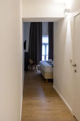 a bedroom with a bed and a room with a window at Hotel Retro in Brussels
