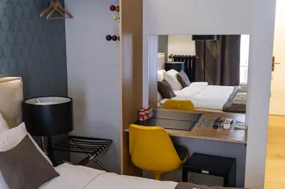 a hotel room with a desk and a mirror at Hotel Retro in Brussels