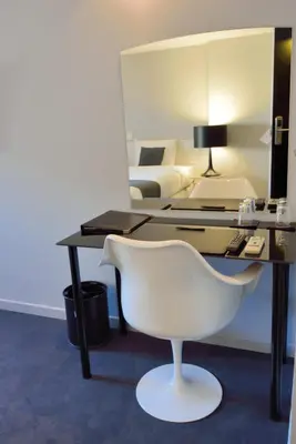 a desk with a white chair in a room at Hotel Retro in Brussels