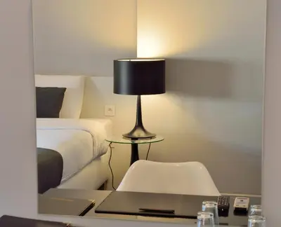a bedroom with a bed and a table with a lamp at Hotel Retro in Brussels