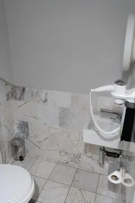 a bathroom with a toilet and a stone wall at Hotel Retro in Brussels