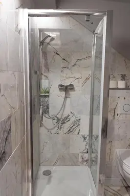 a bathroom with a shower with a sink and a toilet at Hotel Retro in Brussels