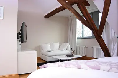 a room with two beds and a couch at B&B AubergInn in Tessenderlo