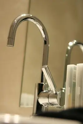 a bathroom sink with a toothbrush holder next to a faucet at B&B AubergInn in Tessenderlo