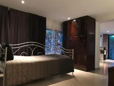 a bedroom with a bed and a large window at The Suite Escape Suite Wood in Sint-Lievens-Houtem