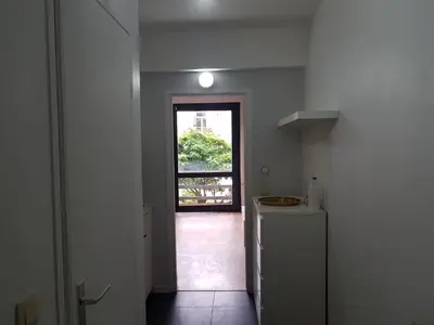 a hallway with a door to a kitchen with a window at Suite minimalist 50m2 in Brussels