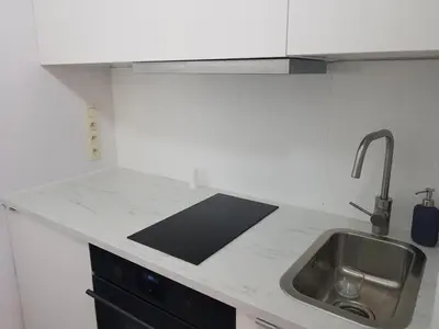 a kitchen with a sink and a counter top at Suite minimalist 50m2 in Brussels