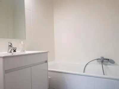 a white bathroom with a tub and a sink at Suite minimalist 50m2 in Brussels