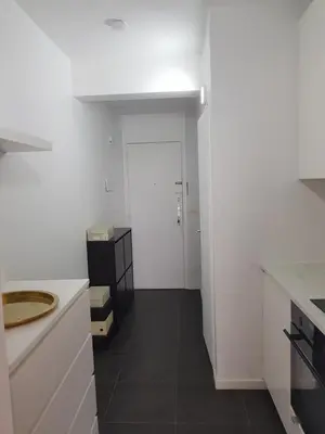 a kitchen with white walls and a black floor at Suite minimalist 50m2 in Brussels