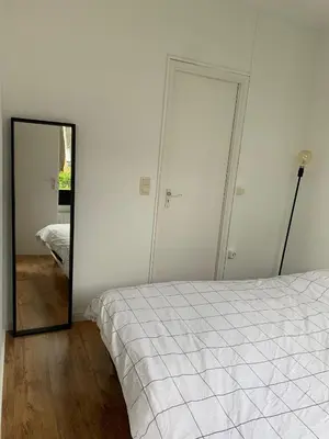 a bedroom with a bed and a mirror at Suite minimalist 50m2 in Brussels