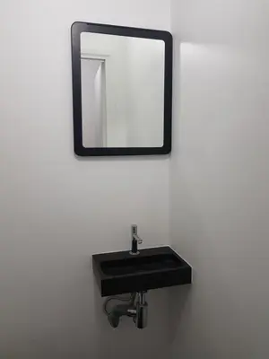 a black sink with a mirror on a wall at Suite minimalist 50m2 in Brussels