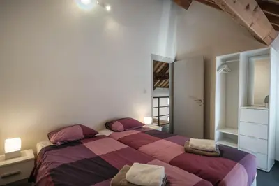two beds in a bedroom with purple and pink sheets at Craywinckelhof Wagenhuis Horst in Lubbeek