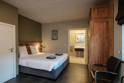 a bedroom with a bed and a bathroom with a sink at Craywinckelhof Wagenhuis Horst in Lubbeek